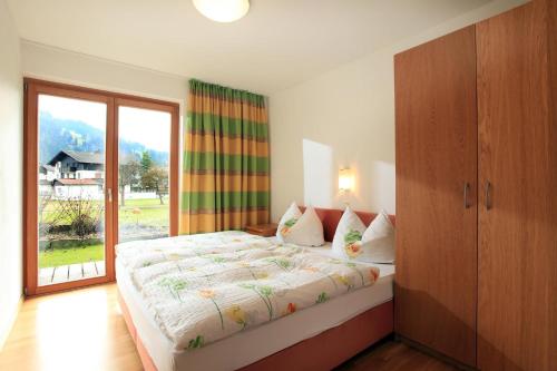 a bedroom with a large bed and a large window at Reiterhof in Westendorf