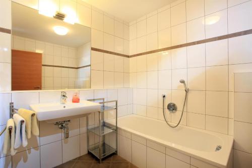 a bathroom with a shower and a sink and a tub at Reiterhof in Westendorf