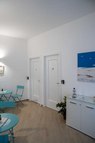 een kamer met 2 tafels en een tafel en stoelen bij Il vicolo di Clara B&B in Diamante