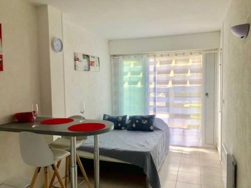 une chambre avec un lit, une table et une fenêtre dans l'établissement Studio 88, Port Nature 1 au village naturiste, au Cap d'Agde