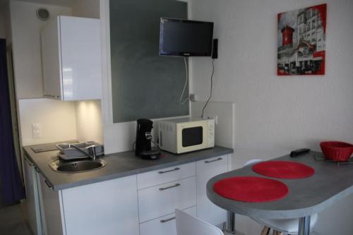 une petite cuisine avec une table et un micro-ondes dans l'établissement Studio 88, Port Nature 1 au village naturiste, au Cap d'Agde