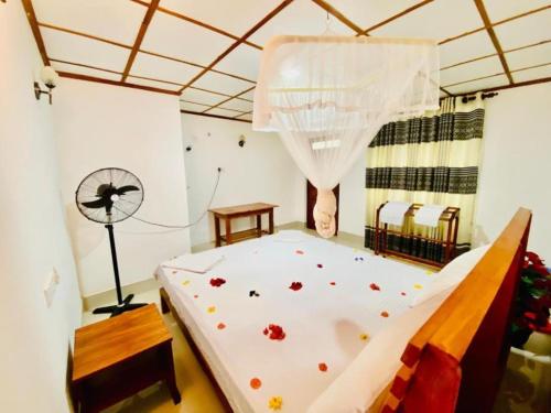 a bedroom with a bed with flowers on it at Rock Lake Home Stay in Sigiriya