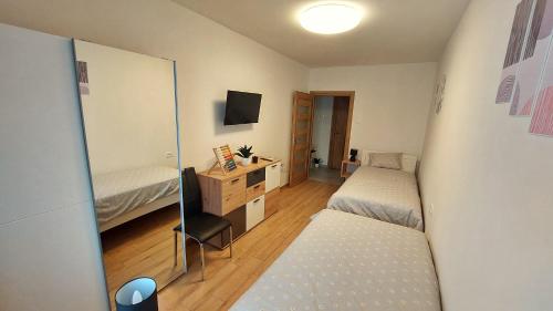 a bedroom with two beds and a desk and a mirror at APARTMAN Zengg in Senj