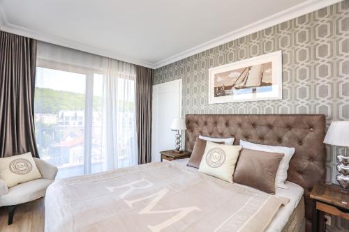 una camera con un grande letto e una grande finestra di Baltic Riviera Concept Apartament z widokiem na morze i las a Międzyzdroje