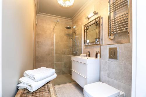e bagno con doccia, servizi igienici e lavandino. di Baltic Riviera Concept Apartament z widokiem na morze i las a Międzyzdroje