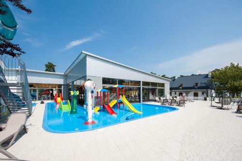 uma piscina com escorrega e um parque infantil em Apartamenty Klifowa 7 em Niechorze