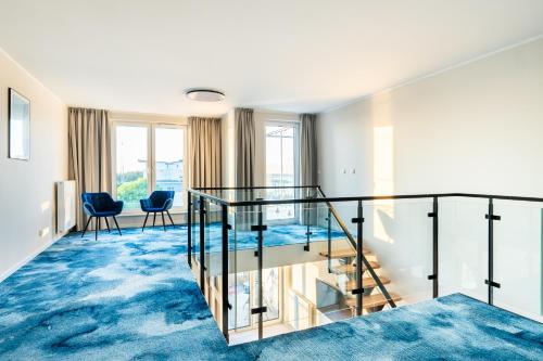 a glass staircase in a room with blue carpet at Art Boulevard in Mrzeżyno