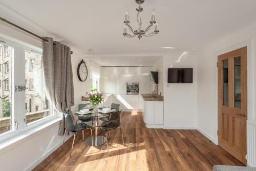 a dining room and living room with a chandelier at Gilmour's Entry Apartment in Edinburgh