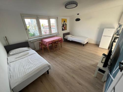 a room with two beds and two tables in it at Murano Apartaments City Center Duo in Warsaw