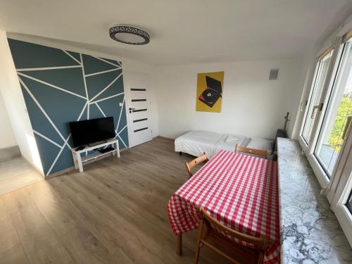 a room with a table and a bed and a television at Murano Apartaments City Center Duo in Warsaw
