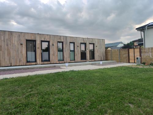 a building with windows on the side of a yard at Daro tiny house in Vama Veche