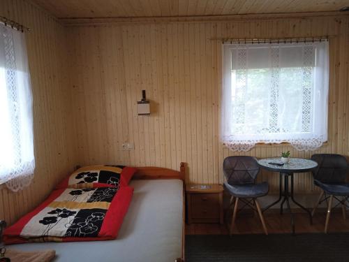 a bedroom with a bed and a table and two chairs at NOCLEGI KAMEX dom 12-osobowy in Olsztyn