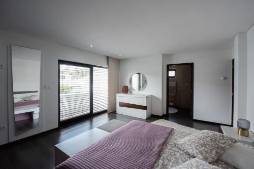 a white bedroom with a bed and a mirror at Casa da Perafita /Matosinhos, 2 Km from the beach in Perafita