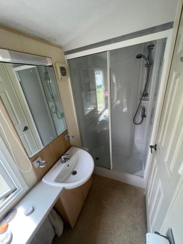 a bathroom with a shower and a sink at Bryn Morfa Holiday Park Conwy North Wales in Conwy