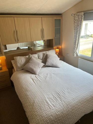 a bedroom with a bed with white sheets and a window at Bryn Morfa Holiday Park Conwy North Wales in Conwy