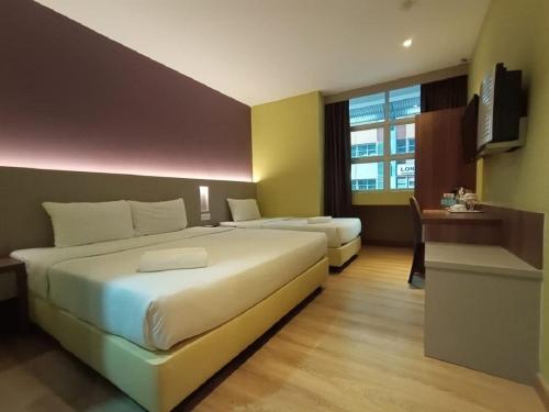 a hotel room with two beds and a television at Yee Hotel Permas in Johor Bahru