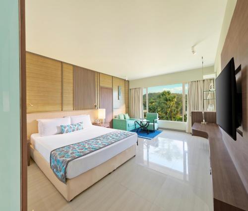 ein Hotelzimmer mit einem Bett und einem TV in der Unterkunft The Resort in Mumbai