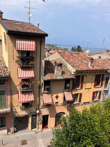 a building with red and white striped awnings on it at The Tower Of The Old King in Desenzano del Garda