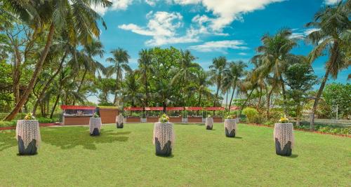 a row of stone monuments in a park with palm trees at The Resort in Mumbai