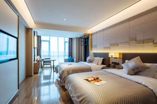 una camera d'albergo con due letti e un tavolo di Morning Hotel, Changsha Huanghua International Airport a Gutang