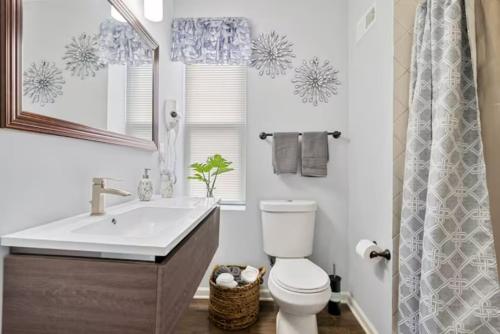 Upscale Luxury Suites Minutes From Center City في فيلادلفيا: حمام مع حوض ومرحاض ومرآة