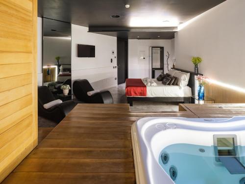 a bathroom with a tub and a bedroom with a bed at Secret Garden Resort & Spa in Palma Campania