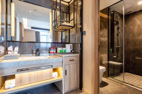 a bathroom with a sink and a shower at Morning Hotel, Changsha Huanghua International Airport in Gutang