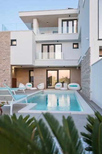 an exterior view of a house with a swimming pool at Villa Fortunal in Murter
