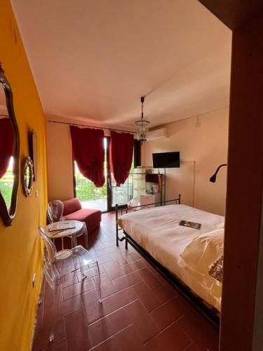 a bedroom with a bed and a couch and a tv at The Queen Tower in Desenzano del Garda