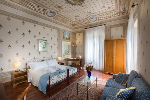 a bedroom with a large bed and a couch at Hotel Camerlengo in Corridonia