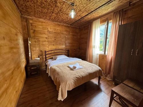 a bedroom with a bed in a wooden room at Guest House end maran ,,vazis saxli,, in Gegelidzeebi