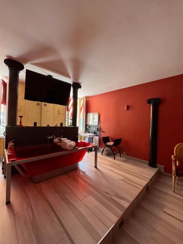 a living room with a red wall and a boat on a wooden floor at The Queen Tower in Desenzano del Garda