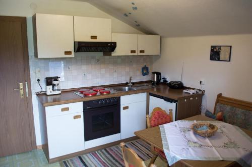 a kitchen with white appliances and a table and a tableablish at Ferienhaus Riedlsperger in Fieberbrunn