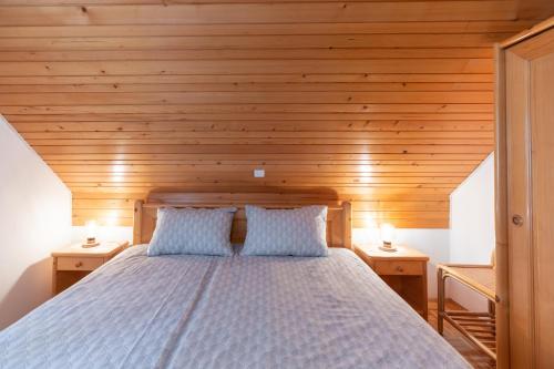1 dormitorio con 1 cama con techo de madera en Apartment Vidmar en Bohinj
