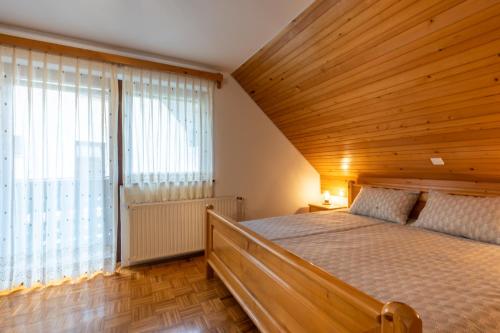 um quarto com uma cama e uma grande janela em Apartment Vidmar em Bohinj