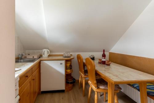 uma cozinha com uma mesa de madeira e um lavatório em Apartment Vidmar em Bohinj