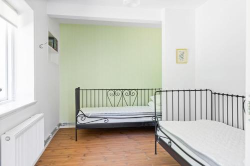 1 dormitorio con 2 camas en una habitación con paredes verdes en Raftarp - Country side cottage in the woods en Sjöbo