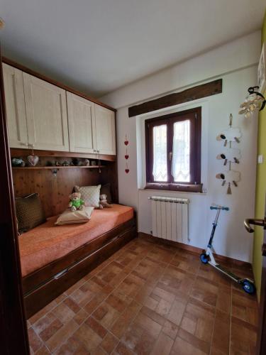 a bedroom with a bed and a window and a scooter at La Libellula apartment (Il tuo Chalet sul colle) in Castel di Sangro