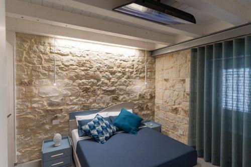 um quarto com uma cama e uma parede de pedra em Lovely Modern Apartment em Modica