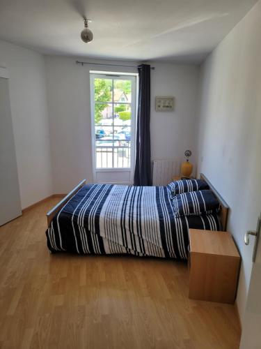 une chambre avec un lit et une fenêtre dans l'établissement Appartement meublé Duplex T3., à Baume-les-Dames