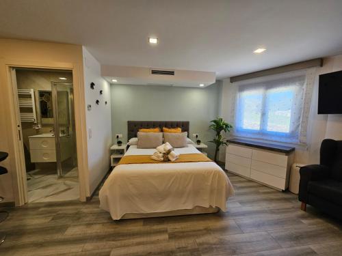 a bedroom with a large bed and a television at Loft con Jacuzzi os Arcos in Sober