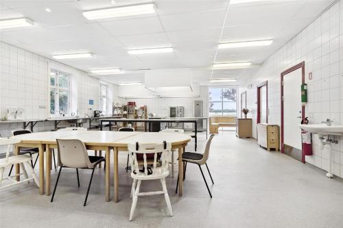 a large kitchen with a large table and chairs at Sigerslevhus Stevns Klint in Store Heddinge