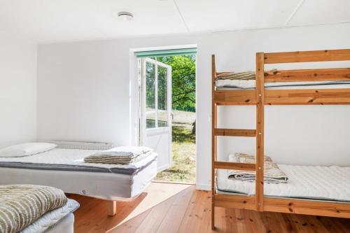 um quarto com 2 beliches e uma porta em Jocksborg - Country side cottage in the woods em Sjöbo