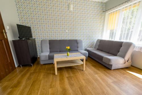 a living room with two couches and a coffee table at Domki MIKO in Mikoszewo