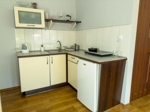a small kitchen with a sink and a microwave at Domki MIKO in Mikoszewo