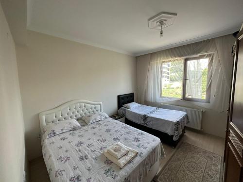 um quarto com 2 camas e uma janela em VIP DAİRE DENİZ MANZARALI em Degirmen