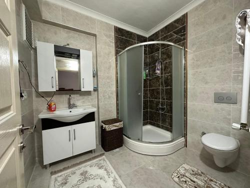a bathroom with a shower and a toilet and a sink at VIP DAİRE DENİZ MANZARALI in Degirmen