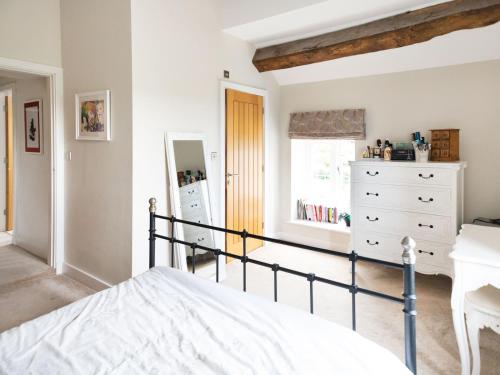 a bedroom with a bed and a dresser and a window at Pass the Keys Stunning Cheshire Barn with HotTub in Sandbach