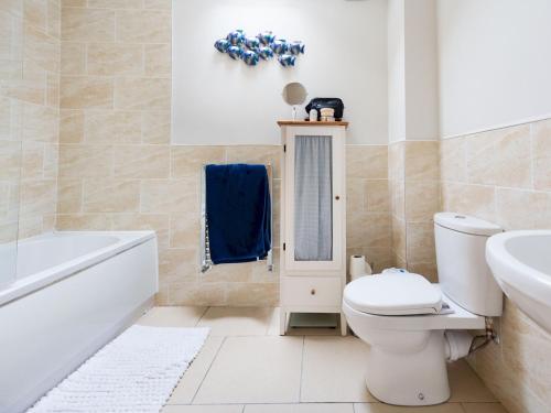 a bathroom with a toilet and a tub and a sink at Pass the Keys Stunning Cheshire Barn with HotTub in Sandbach