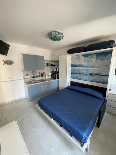 a bedroom with a blue bed and a kitchen at Le Vele Luxury Mini Apartment in Chioggia
